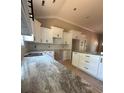 Modern kitchen featuring white cabinets, black hardware, granite countertops, subway tile backsplash, and a spacious island at 4940 Southview Dr, Hickory, NC 28602
