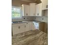 Close-up of the kitchen featuring white cabinets, granite countertops, a stainless steel sink, and subway tile backsplash at 4940 Southview Dr, Hickory, NC 28602