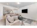 Bright living room featuring a large sofa, modern rug, and flat-screen TV at 5010 Arbordale Way, Mount Holly, NC 28120