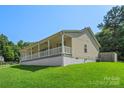 Cozy home featuring a covered porch, complemented by a well-maintained lawn at 5206 Crane Point Dr, Charlotte, NC 28227