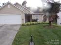 Charming single-story home with a well-manicured lawn and palm tree at 569 River View Dr, Lowell, NC 28098