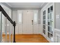 Bright foyer features hardwood floors, white trim, and a stairway with a black handrail at 9605 Mountain Ivy Ct, Charlotte, NC 28210