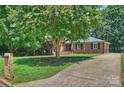 Well-maintained brick home with lush green lawn and mature trees along the driveway at 1008 Dumbarton Rd, Gastonia, NC 28054