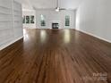 Expansive living room featuring hardwood floors, a fireplace, and built-in shelves at 11103 Fox Cove Dr, Charlotte, NC 28273
