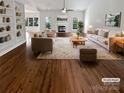 Bright living room with fireplace, ceiling fan, hardwood floors, and large windows that provide natural light at 11103 Fox Cove Dr, Charlotte, NC 28273