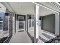 Inviting covered front porch featuring a modern black front door and craftsman style details at 1169 Hollis Sw Cir, Concord, NC 28025