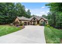 Beautiful stone home showcasing mature trees, a long driveway and meticulous landscaping at 146 Bullfinch Rd, Mooresville, NC 28117