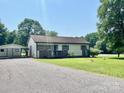 Inviting home with a cozy front porch, carport and green lawn at 1678 Nelson Dr, Newton, NC 28658