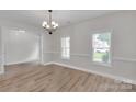 Bright and open dining room with laminate wood floors, two windows and a decorative chandelier at 275 Dorothy Dr, China Grove, NC 28023