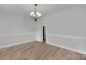 Well-lit dining room showcasing wainscoting, laminate wood floors and a decorative chandelier at 275 Dorothy Dr, China Grove, NC 28023