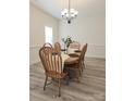 Bright dining room features a wood table with six chairs, a decorative chandelier, and light gray wood flooring at 275 Dorothy Dr, China Grove, NC 28023