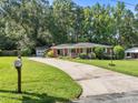 Quaint brick home with a long driveway and detached garage nestled among mature trees at 331 Elwood St, Kannapolis, NC 28081