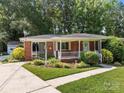 Close-up of a brick home featuring a welcoming front porch and well-maintained landscaping at 331 Elwood St, Kannapolis, NC 28081