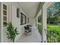 A covered porch with two black chairs, white brick wall, and black framed windows at 4209 Windwood Cir, Charlotte, NC 28226