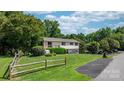 Inviting home showcasing a spacious lawn, split rail fence, and an asphalt driveway at 4278 Harbor Ln, Sherrills Ford, NC 28673