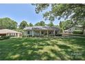 Inviting single-story home featuring a green lawn and mature trees in a serene neighborhood setting at 5301 Addison Dr, Charlotte, NC 28211