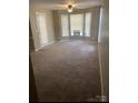 An airy living room showcases plush carpeting, bay windows, and ample natural light at 6260 Rosecroft Dr, Charlotte, NC 28215