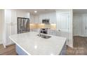 Bright kitchen with a large island, stainless steel appliances, white cabinets, and tile backsplash at 633 Portside Dr, Davidson, NC 28036
