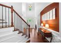 Bright foyer with high ceilings, hardwood floors, staircase, and elegant decor at 7327 Snowbird Ct, Mint Hill, NC 28227