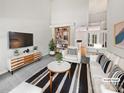 Bright living room features high ceilings, modern furniture, and a stylish striped rug, creating a cozy and inviting space at 9121 Charminster Ct, Charlotte, NC 28269