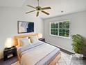 The main bedroom offers a comfortable retreat with a large window overlooking lush greenery, providing natural light and tranquility at 9121 Charminster Ct, Charlotte, NC 28269