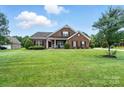 Beautifully landscaped brick home with a large lawn and inviting facade at 1006 Spring Rose Ln, Matthews, NC 28104
