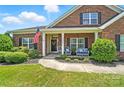 Close up of the porch with detailed trim and a welcoming seating area at 1006 Spring Rose Ln, Matthews, NC 28104