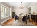 Bright dining room featuring hardwood floors, modern chandelier, large windows, and a stylish table setting at 101 Mcalway Rd, Charlotte, NC 28211