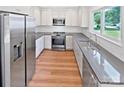 Modern kitchen features stainless steel appliances, stone countertops, and white cabinets at 10934 Coachman Cir, Charlotte, NC 28277