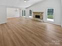 Open-concept floorplan includes a stone fireplace, wood floors, and views of the yard at 10934 Coachman Cir, Charlotte, NC 28277