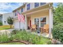 Charming front porch with rocking chairs, flowers, and an American flag at 1288 Century Dr, Clover, SC 29710