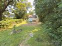 Backyard view of a home featuring a small deck and lots of grassy area at 179 Duval Nw St, Concord, NC 28025
