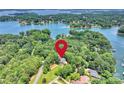 Scenic aerial view of a house nestled amongst lush trees on a lake, indicated by a red pin at 19900 Stough Farm Rd, Cornelius, NC 28031