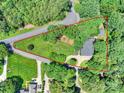 A bird's eye view of a property with a red boundary line, surrounded by lush greenery and trees at 19900 Stough Farm Rd, Cornelius, NC 28031