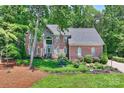 Charming brick home featuring a stone accent, well-maintained lawn, and beautiful water fountain at 19900 Stough Farm Rd, Cornelius, NC 28031