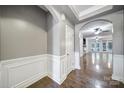 Elegant hallway with wainscoting, hardwood floors, and archway leading to a spacious living area at 329 Wave Crest Dr, Tega Cay, SC 29708