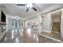Open-concept living room with hardwood floors, ceiling fans, and seamless flow to kitchen and dining areas at 329 Wave Crest Dr, Tega Cay, SC 29708