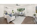 Bright living room with hardwood floors, large windows, and neutral-toned furniture at 4219 Tipperary Pl, Charlotte, NC 28215