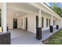 Inviting covered front porch with brick columns, offering a cozy outdoor space and curb appeal at 509 8Th Avenue Ext, Cramerton, NC 28032