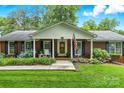 Charming red brick home with an inviting front porch, American flag, and flowering shrubs at 701 4Th Ne Ave, Conover, NC 28613