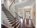 Elegant foyer showcasing a staircase with wood steps, iron railings, and gleaming hardwood floors throughout at 901 Deercross Ln, Waxhaw, NC 28173
