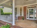 Inviting front porch with rocking chairs and a 'hello' welcome mat leading to the front door of the house at 901 Deercross Ln, Waxhaw, NC 28173