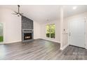 Bright living room featuring a stone fireplace and gray flooring at 9122 Nathaniel Russell Ln, Charlotte, NC 28227