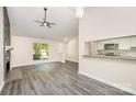 Open living space with modern gray flooring, stone fireplace, and views into the kitchen at 9122 Nathaniel Russell Ln, Charlotte, NC 28227