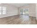 Spacious living room with hardwood floors, large window, and glass doors to the balcony at 9271 Meadow Vista Rd, Charlotte, NC 28213