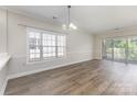 Bright living room featuring hardwood floors, a large window, and sliding doors to a patio at 9271 Meadow Vista Rd, Charlotte, NC 28213
