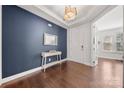 Inviting foyer with dark blue accent wall, hardwood floors, stylish console table, and a decorative mirror at 12415 Es Draper Dr, Huntersville, NC 28078