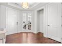 Bright foyer featuring white trim, hardwood floors, glass-paneled office doors, and a view of the home gym at 12415 Es Draper Dr, Huntersville, NC 28078