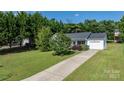 A beautiful bird's eye view of a house with a large grassy yard and tall trees at 1265 39Th Street Cir, Hickory, NC 28602