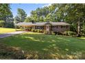 Lovely single-story brick home with a covered parking area, landscaped lawn, and mature trees at 143 Bostian Lake Rd, Statesville, NC 28677